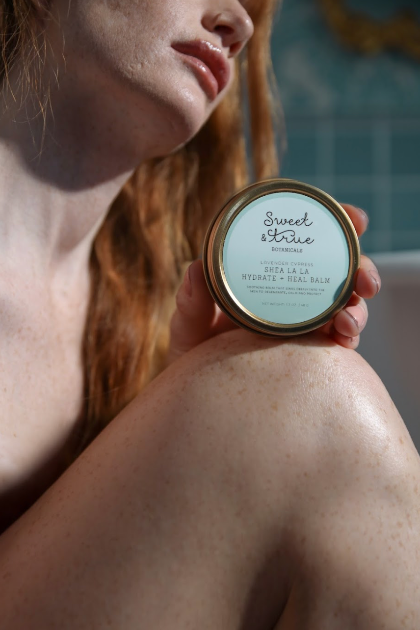 Model applying Lavender Cypress Balm to her shoulder